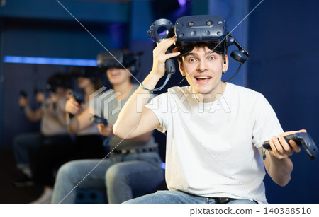 Excited young guy in VR glasses playing virtual reality game Excited young guy in VR glasses playing virtual reality game 140388510