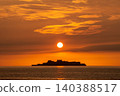 黃昏時分，軍艦島矗立在地平線上，沐浴在壯麗的夕陽中。 140388517
