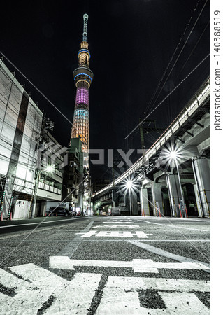 The illuminated Tokyo Skytree soaring into the night sky, and the cityscape along the elevated railway line. 140388519