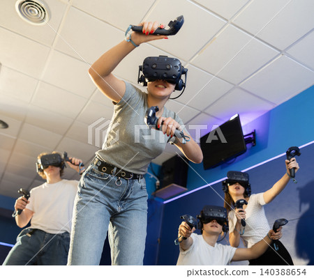 Excited young woman in VR goggles having fun in virtual reality room Excited young woman in VR goggles having fun in virtual reality room 140388654