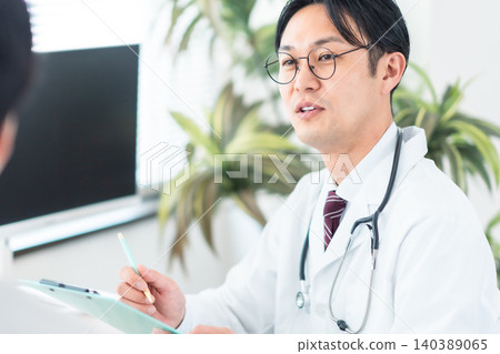 一位身穿白大褂的醫生微笑著與病人交談。身體檢查、診所、健康管理、壓力測試。 一位身穿白大褂的醫生微笑著與病人交談。身體檢查、診所、健康管理、壓力測試。 140389065
