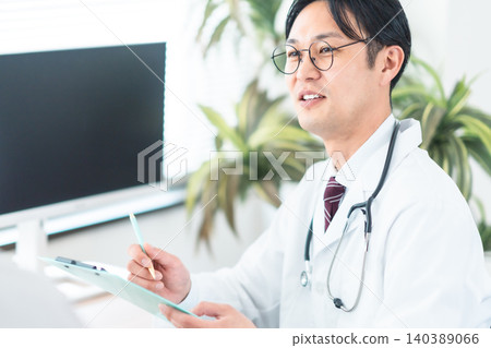 一位身穿白大褂的醫生微笑著與病人交談。身體檢查、診所、健康管理、壓力測試。 一位身穿白大褂的醫生微笑著與病人交談。身體檢查、診所、健康管理、壓力測試。 140389066