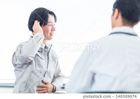 一名工程師在諮詢公司醫生時抱怨頭痛。 一名工程師在諮詢公司醫生時抱怨頭痛。 140389074
