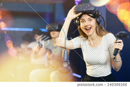 girl is exhilarated by turn of events in VR game and moved virtual reality glasses to forehead girl is exhilarated by turn of events in VR game and moved virtual reality glasses to forehead 140389168