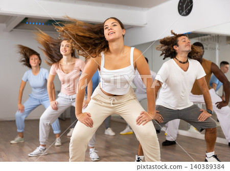 Women and man performing modern dance in fitness studio Women and man performing modern dance in fitness studio 140389384