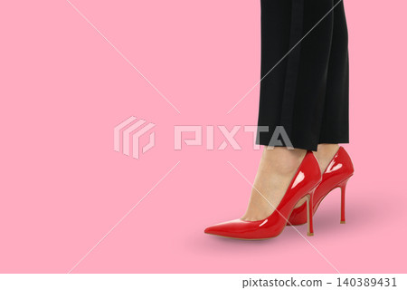 Woman wears red heels and stands with black pants Woman wears red heels and stands with black pants 140389431
