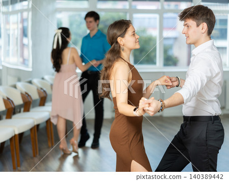 Dance studio where young couples in festive clothes learn to dance swing Dance studio where young couples in festive clothes learn to dance swing 140389442