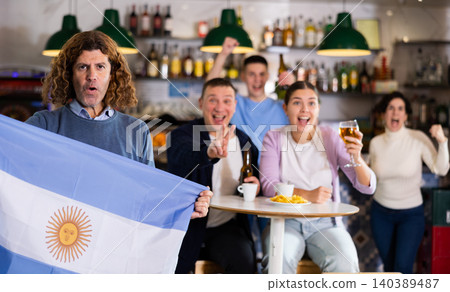 Company of joyful fans of different ages waving flag of Argentina and celebrating victory of favorite team in sports bar Company of joyful fans of different ages waving flag of Argentina and celebrating victory of favorite team in sports bar 140389487