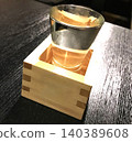Enjoying sake at an izakaya (sake served in a masu cup and glass, overflowing in the "mokkiri" style) 140389608