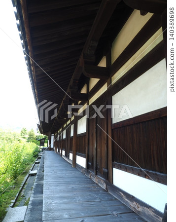 A national treasure corridor stretches into the height of silence. A refined wooden structure and fresh greenery stand behind the Zen room of the World Heritage site, Gangoji Temple. A national treasure corridor stretches into the height of silence. A refined wooden structure and fresh greenery stand behind the Zen room of the World Heritage site, Gangoji Temple. 140389698