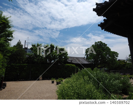A view of the East Gate in early summer from the eaves of a national treasure. The refreshing blue sky and lush new greenery spread across the grounds of the World Heritage site, Gangoji Temple. A view of the East Gate in early summer from the eaves of a national treasure. The refreshing blue sky and lush new greenery spread across the grounds of the World Heritage site, Gangoji Temple. 140389702
