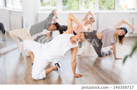 Young guy practicing breakdance floor-works in training hall Young guy practicing breakdance floor-works in training hall 140389717