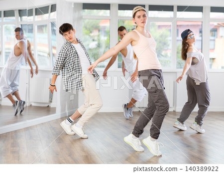Young girl practicing hip hop slide moves in training hall Young girl practicing hip hop slide moves in training hall 140389922