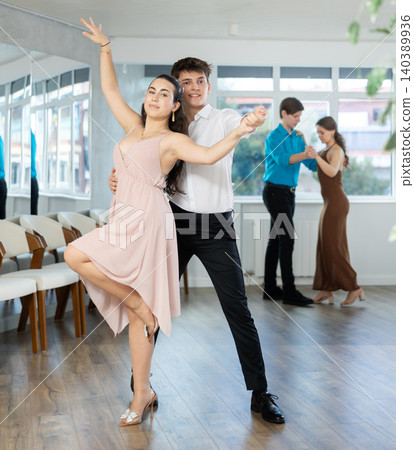 Young couples learning to dance latin american dances in dance studio Young couples learning to dance latin american dances in dance studio 140389936