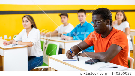 Multiethnic group of people studying together at tables. Focus on African american man Multiethnic group of people studying together at tables. Focus on African american man 140390055