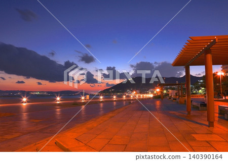 暮色籠罩著須磨海濱公園,許願棕櫚樹和明石海峽大橋沐浴在晨曦之中。 暮色籠罩著須磨海濱公園,許願棕櫚樹和明石海峽大橋沐浴在晨曦之中。 140390164
