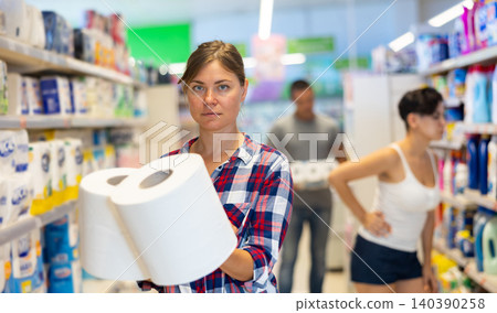Young female shopper choosing paper towels in supermarket Young female shopper choosing paper towels in supermarket 140390258