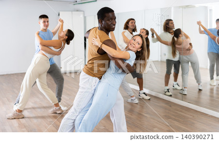 Man and woman in pairs learning to dance waltz in studio Man and woman in pairs learning to dance waltz in studio 140390271