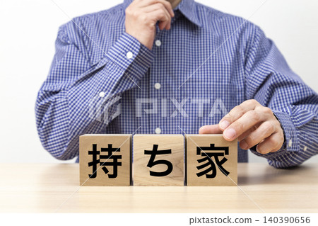 A block with the words "Owned Home" written on it and a man A block with the words "Owned Home" written on it and a man 140390656