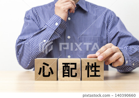 一塊寫著「焦慮」字樣的磚塊和一個男人 140390660