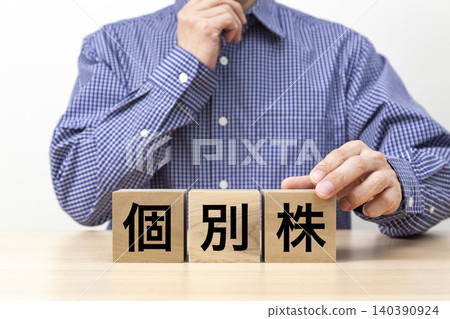 A block with the words "Individual Stocks" written on it and a man A block with the words "Individual Stocks" written on it and a man 140390924