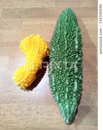 Comparison of fully ripened bitter melon grown in a home garden and when it's ready to eat. Comparison of fully ripened bitter melon grown in a home garden and when it's ready to eat. 140390946