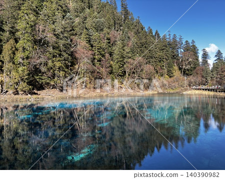 Five-Color Lake reflecting forest and blue sky in Jiuzhaigou National Park Five-Color Lake reflecting forest and blue sky in Jiuzhaigou National Park 140390982