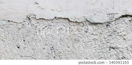 Peeling white plaster wall texture against a cracked concrete surface background. Peeling white plaster wall texture against a cracked concrete surface background. 140391103