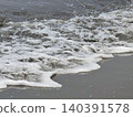 Ocean wave foam washes onto sandy beach shore surface texture 140391578