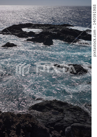 Sunlit Waves Crashing Over Rugged Coastal Rocks Sunlit Waves Crashing Over Rugged Coastal Rocks 140391988