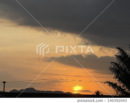 Dramatic Sunrise with Dark Clouds and Golden Horizon Dramatic Sunrise with Dark Clouds and Golden Horizon 140392043