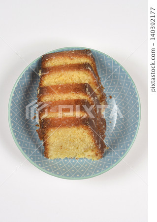 Top view of glazed lemon pound cake slices in a blue bowl 140392177