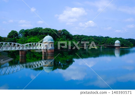 The view of the water intake tower at Lake Tama and the blue sky and white clouds reflected on the lake's surface. The view of the water intake tower at Lake Tama and the blue sky and white clouds reflected on the lake's surface. 140393571