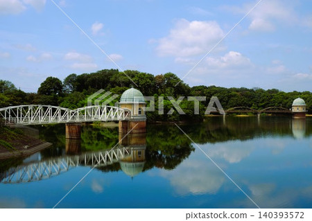 The view of the water intake tower at Lake Tama and the blue sky and white clouds reflected on the lake's surface. The view of the water intake tower at Lake Tama and the blue sky and white clouds reflected on the lake's surface. 140393572