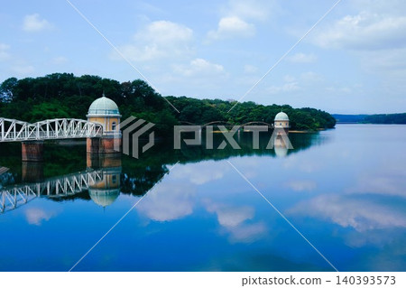The view of the water intake tower at Lake Tama and the blue sky and white clouds reflected on the lake's surface. The view of the water intake tower at Lake Tama and the blue sky and white clouds reflected on the lake's surface. 140393573
