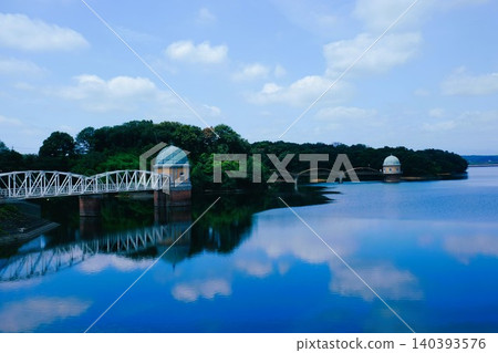 The view of the water intake tower at Lake Tama and the blue sky and white clouds reflected on the lake's surface. The view of the water intake tower at Lake Tama and the blue sky and white clouds reflected on the lake's surface. 140393576