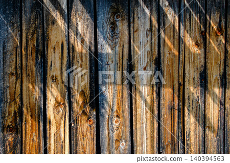 Rustic weathered wood fence texture sunlight and shadow play natural timber background for outdoor design and vintage concepts. 140394563