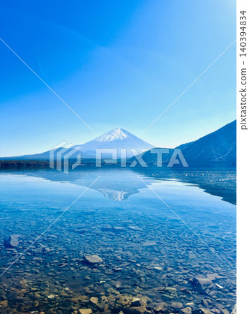 富士山的景色倒映在湖面上,形成一片碧藍的湖面。 富士山的景色倒映在湖面上,形成一片碧藍的湖面。 140394834