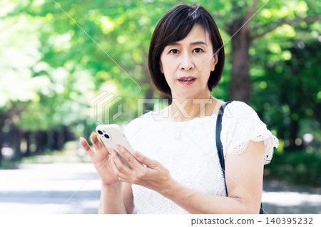 拿著智慧型手機思考的中年婦女 140395232
