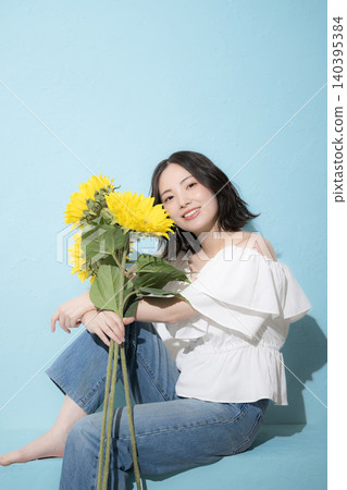 A full-body fashion portrait featuring sunflowers and a refreshing midsummer image. A full-body fashion portrait featuring sunflowers and a refreshing midsummer image. 140395384