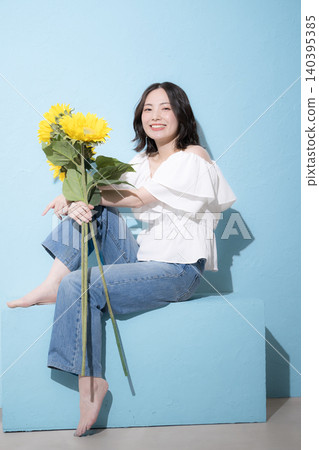A full-body fashion portrait featuring sunflowers and a refreshing midsummer image. A full-body fashion portrait featuring sunflowers and a refreshing midsummer image. 140395385