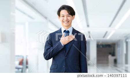 Male businessman standing with his hand on his chest Male businessman standing with his hand on his chest 140397111