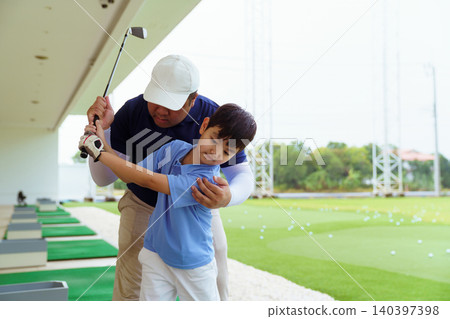 Golf instructor teaching young student proper swing at driving range Golf instructor teaching young student proper swing at driving range 140397398