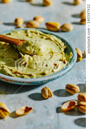 pistachio cream and a wooden spoon on a table 140397432