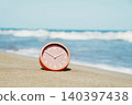a salmon pink clock on a quiet beach 140397438