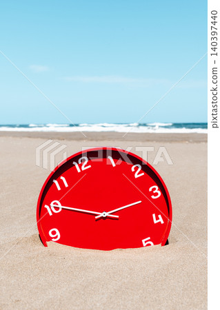 a red clock on a broad deserted beach a red clock on a broad deserted beach 140397440