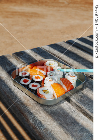 sushi and nigiri fill a metal lunch box on a table 140397445