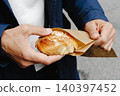 a man unwraps a swedish kanelbulle 140397452