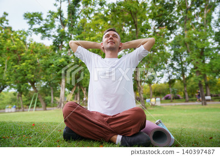 Peaceful man practicing yoga and meditation in green park Peaceful man practicing yoga and meditation in green park 140397487
