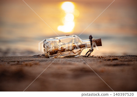 Message in glass bottle on sandy beach at sunset. 140397520
